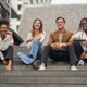 Happy Young Friends Sitting on Outdoor Steps Together Happy Young Friends Sitting on Outdoor Steps Together - PhotoDune Item for Sale