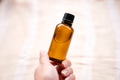 Hand holding amber glass bottles on natural background Hand holding amber glass bottles on natural background - PhotoDune Item for Sale