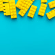 Yellow Plastic Building Blocks on Turquoise Blue Background with Copy Space Yellow Plastic Building Blocks on Turquoise Blue Background with Copy Space - PhotoDune Item for Sale