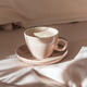 Cappuccino Cup on Cozy Bed with Sunlight and Beige Bedding Cappuccino Cup on Cozy Bed with Sunlight and Beige Bedding - PhotoDune Item for Sale