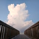 Large puffy white cumulus clouds over beach walkway. Large puffy white cumulus clouds over beach walkway. - PhotoDune Item for Sale