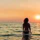 Surfer gets ready to ride waves in ocean during sunset at beach in summer Surfer gets ready to ride waves in ocean during sunset at beach in summer - PhotoDune Item for Sale
