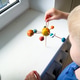The child holds in his hands a model of the solar system, which he himself made from plasticine The child holds in his hands a model of the solar system, which he himself made from plasticine - PhotoDune Item for Sale