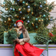 A woman in a red clothes with a bouquet of fir branches walks along the Christmas decorated streets A woman in a red clothes with a bouquet of fir branches walks along the Christmas decorated streets - PhotoDune Item for Sale