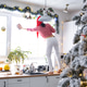 A woman in a Santa hat cleans a kitchen window with Christmas decorations, preparing A woman in a Santa hat cleans a kitchen window with Christmas decorations, preparing - PhotoDune Item for Sale