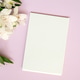 Blank white notepad on pink background with white flowers Blank white notepad on pink background with white flowers - PhotoDune Item for Sale