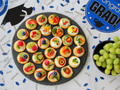 Overhead flat lay of colorful appetizers on marble counter decorated with graduation party supplies Overhead flat lay of colorful appetizers on marble counter decorated with graduation party supplies - PhotoDune Item for Sale