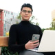 Focused Asian man browsing on mobile phone and laptop Focused Asian man browsing on mobile phone and laptop - PhotoDune Item for Sale