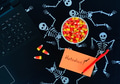 Halloween & technology flat lay with candy corn next to laptop on a dark skeletons background. Halloween & technology flat lay with candy corn next to laptop on a dark skeletons background. - PhotoDune Item for Sale