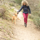 Curly and blonde hair, mountaineer woman and her dog walking through the mountains. Curly and blonde hair, mountaineer woman and her dog walking through the mountains. - PhotoDune Item for Sale