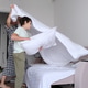 mother and son work together make bed, with mother shaking out a blanket and child holding pillow. mother and son work together make bed, with mother shaking out a blanket and child holding pillow. - PhotoDune Item for Sale