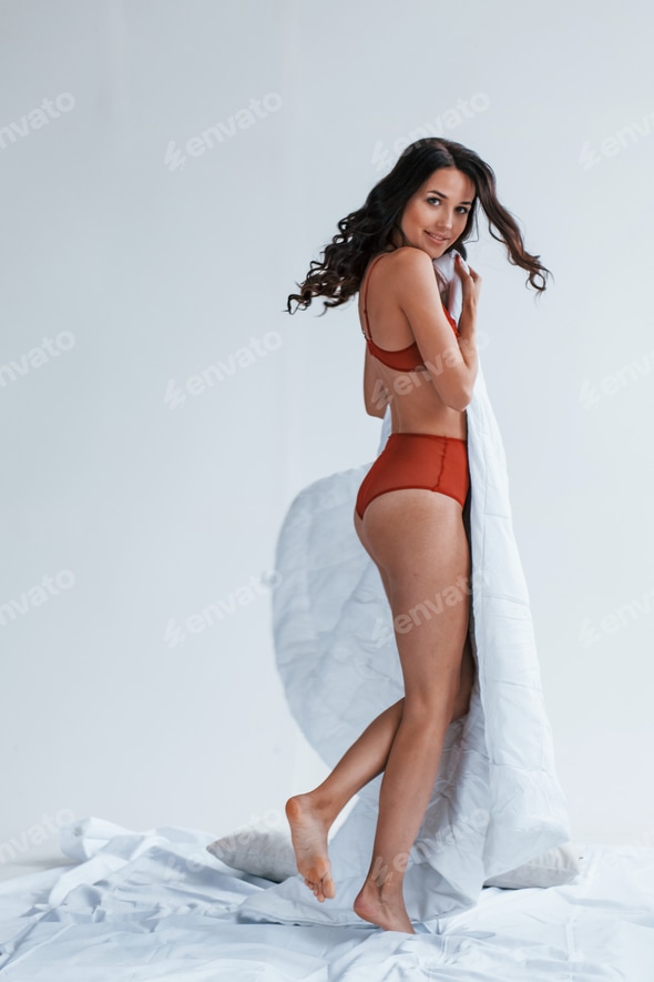 Beautiful young brunette in underwear standing in studio and covering her sexy body by white towel Stock Photo by mstandret Beautiful young brunette in underwear standing in studio and covering her sexy body by white towel Stock Photo by mstandret