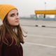 Young beautiful woman in burgundy coat and yellow hat walks along the roof of the parking lot. Young beautiful woman in burgundy coat and yellow hat walks along the roof of the parking lot. - PhotoDune Item for Sale