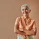 Beautiful stylish middle-aged woman standing on beige background and slyly looking sideways at adver Beautiful stylish middle-aged woman standing on beige background and slyly looking sideways at adver - PhotoDune Item for Sale