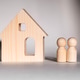 Wooden house model alongside two wooden figurines representing a couple Wooden house model alongside two wooden figurines representing a couple - PhotoDune Item for Sale