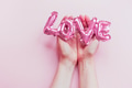 Love concept. Inflatable pink balloon in hands Love concept. Inflatable pink balloon in hands - PhotoDune Item for Sale