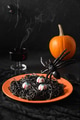 Halloween Italian black pasta decorated funny spiders in orange plate on white. Halloween Italian black pasta decorated funny spiders in orange plate on white. - PhotoDune Item for Sale
