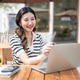Pretty asian woman looking and pointing a pen at laptop while sitting at wooden table in garden cafe Pretty asian woman looking and pointing a pen at laptop while sitting at wooden table in garden cafe - PhotoDune Item for Sale