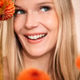Smiling woman with long blonde hair surrounded by vibrant orange flowers Smiling woman with long blonde hair surrounded by vibrant orange flowers - PhotoDune Item for Sale