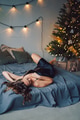 portrait of a beautiful European girl, who lies on the bed in the light of Christmas garlands, joyfu portrait of a beautiful European girl, who lies on the bed in the light of Christmas garlands, joyfu - PhotoDune Item for Sale