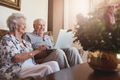 Smiling senior couple using laptop at home Smiling senior couple using laptop at home - PhotoDune Item for Sale