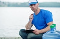 Delivery man sitting with clipboard water bottles outdoor. Delivery man sitting with clipboard water bottles outdoor. - PhotoDune Item for Sale