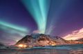 Aurora borealis on the Lofoten islands, Norway. Green northern lights above mountains. Aurora borealis on the Lofoten islands, Norway. Green northern lights above mountains. - PhotoDune Item for Sale