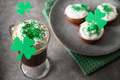 Irish coffee in green cup and festive cupcakes for St Patricks Day. Close up. Irish coffee in green cup and festive cupcakes for St Patricks Day. Close up. - PhotoDune Item for Sale