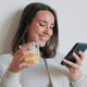 Smiling Woman Texting at Home With Juice Smiling Woman Texting at Home With Juice - PhotoDune Item for Sale