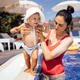 Young woman holding a toddler in a swimming pool, both enjoying a sunny day Young woman holding a toddler in a swimming pool, both enjoying a sunny day - PhotoDune Item for Sale