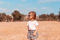 Little girl walking alone in field with yelllow grass. Scenic countryside life, unity with nature Little girl walking alone in field with yelllow grass. Scenic countryside life, unity with nature - PhotoDune Item for Sale