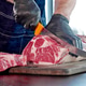Chef cuts raw meat on the wood board with the knife, close-up Chef cuts raw meat on the wood board with the knife, close-up - PhotoDune Item for Sale