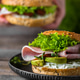 Bagel with butter, ham and avocado on a wooden table at breakfast Bagel with butter, ham and avocado on a wooden table at breakfast - PhotoDune Item for Sale