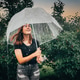 Preteen girl out in the rain under an umbrella looking up smiling. Preteen girl out in the rain under an umbrella looking up smiling. - PhotoDune Item for Sale