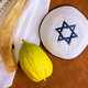 Bright etrog citrus on an ornate silver platter beside an open book Jewish fabric in cozy setting Bright etrog citrus on an ornate silver platter beside an open book Jewish fabric in cozy setting - PhotoDune Item for Sale