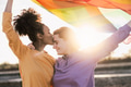Happy lesbian couple having romantic moments while holding rainbow flag outdoor Happy lesbian couple having romantic moments while holding rainbow flag outdoor - PhotoDune Item for Sale