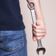 Man hand holding large metal wrench with tight grip, plain background Man hand holding large metal wrench with tight grip, plain background - PhotoDune Item for Sale