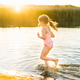 A little girl in the summer on the river runs along the shore, salvation in the heat A little girl in the summer on the river runs along the shore, salvation in the heat - PhotoDune Item for Sale