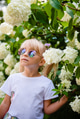 Beautiful little girl in stylish sunglasses in blooming flowers. Beautiful little girl in stylish sunglasses in blooming flowers. - PhotoDune Item for Sale