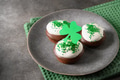 Festive chocolate cupcakes for Happy St Patricks Day on green background. Close up. Festive chocolate cupcakes for Happy St Patricks Day on green background. Close up. - PhotoDune Item for Sale