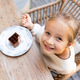 Smiling young girl sitting at an outdoor cafe table with a dessert Smiling young girl sitting at an outdoor cafe table with a dessert - PhotoDune Item for Sale