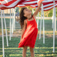 Smiling girl in red dress looking at American flag on Memorial Day, USA Smiling girl in red dress looking at American flag on Memorial Day, USA - PhotoDune Item for Sale