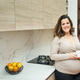 Pregnant woman holding mug in home kitchen Pregnant woman holding mug in home kitchen - PhotoDune Item for Sale