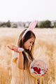Teen girl in wheat field with easter bunny ears collecting painted eggs into basket Teen girl in wheat field with easter bunny ears collecting painted eggs into basket - PhotoDune Item for Sale