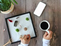Flat lay view of mockup friendly mobile device and relaxed woman drinking coffee doing a Zen garden Flat lay view of mockup friendly mobile device and relaxed woman drinking coffee doing a Zen garden - PhotoDune Item for Sale