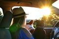 Woman with dogs watching a sunset from her car on a road trip during golden hour. Woman with dogs watching a sunset from her car on a road trip during golden hour. - PhotoDune Item for Sale