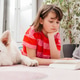 A teenage girl lies on the floor and reads a book, next to her lies a white Swiss shepherd A teenage girl lies on the floor and reads a book, next to her lies a white Swiss shepherd - PhotoDune Item for Sale