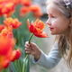Adorable little caucasian blonde girl smiling in tulip field at spring day Adorable little caucasian blonde girl smiling in tulip field at spring day - PhotoDune Item for Sale