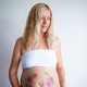 The belly of a pregnant blonde woman on a light background, the girl put her hand on her stomach The belly of a pregnant blonde woman on a light background, the girl put her hand on her stomach - PhotoDune Item for Sale