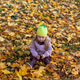 little blonde girl in a bright hat and dress is sitting in bright autumn leaves with a stick in her little blonde girl in a bright hat and dress is sitting in bright autumn leaves with a stick in her - PhotoDune Item for Sale
